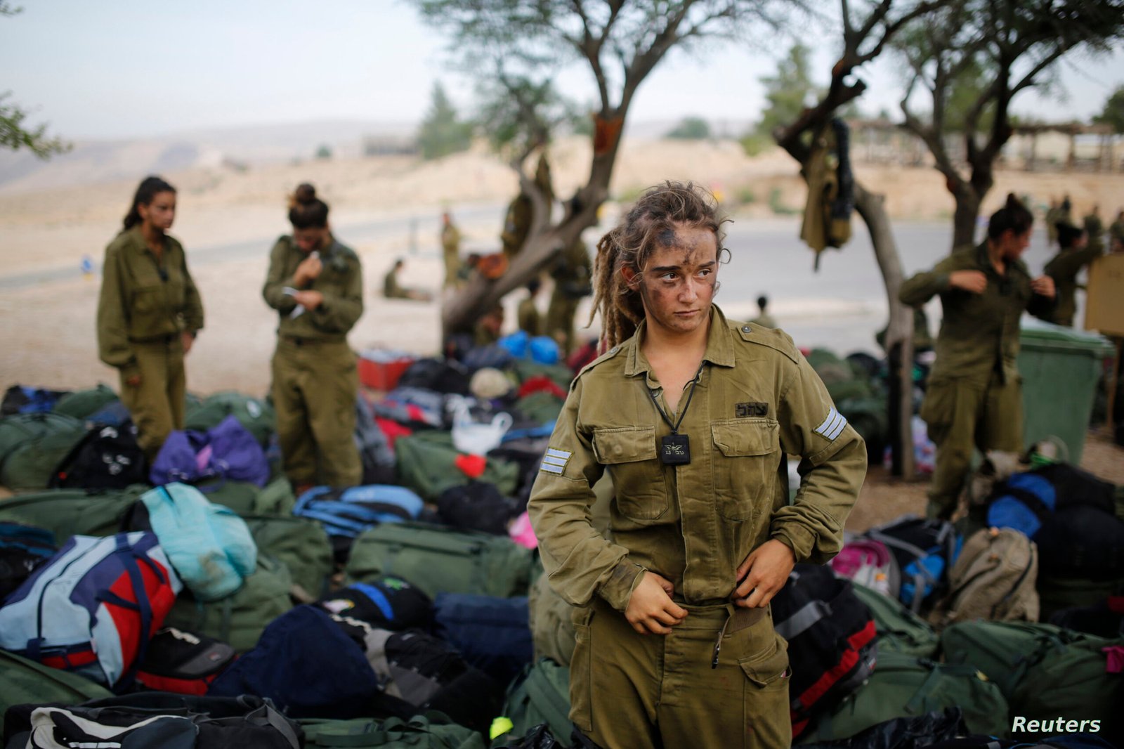Israeli soldier of Caracal battalion stands next to backpacks after finishing march in Israel’s Negev desert